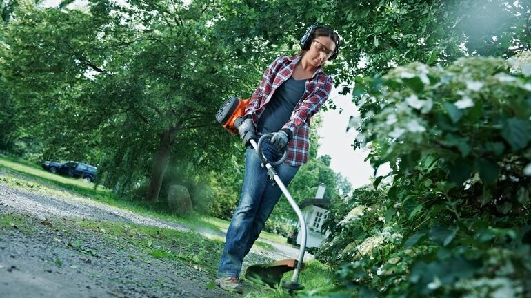 donna che utilizza decespugliatore