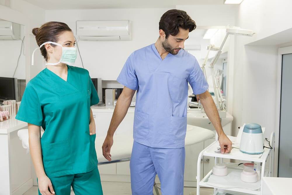 uomo e donna in divise sanitarie