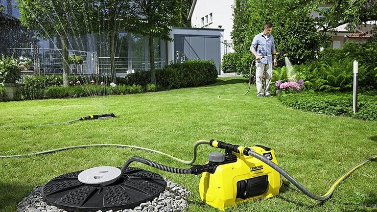 uomo che innaffia giardino ed elettropompa