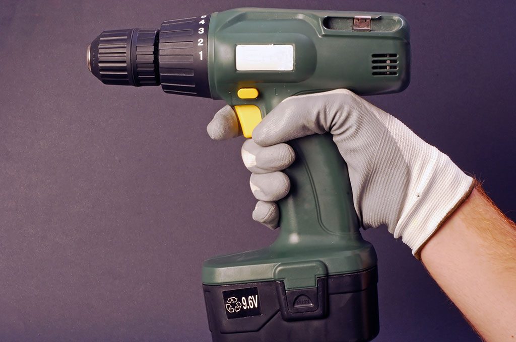 persona che impugna un trapano avvitatore a batteria