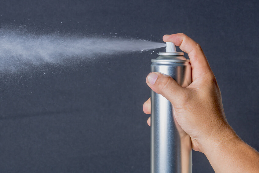 persona spruzza bomboletta spray